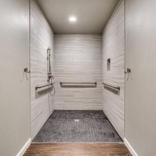 Interior view of a modern elevator with metal railings and neutral colors.
