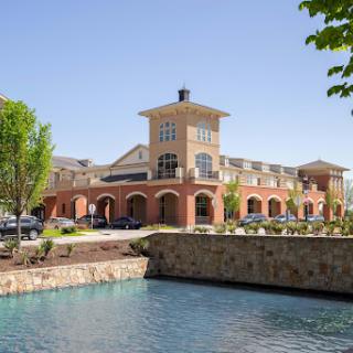 A charming commercial building situated beside a serene body of water.