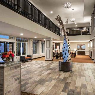 A modern and spacious lobby featuring a central art sculpture and contemporary decor.