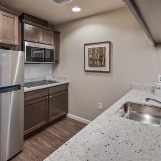 A modern kitchen featuring stainless steel appliances and wood cabinets.