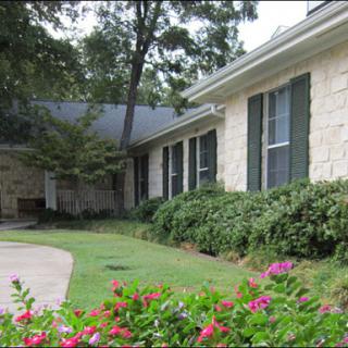 A charming house with a well-maintained garden featuring colorful flowers.