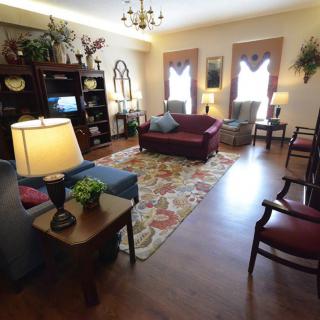 A cozy living room with a variety of seating options, decorative elements, and warm lighting.