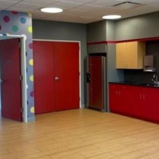 A modern kitchen area featuring bold red cabinets and playful polka dot accents.