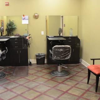 An interior view of a salon with chairs and mirrors.