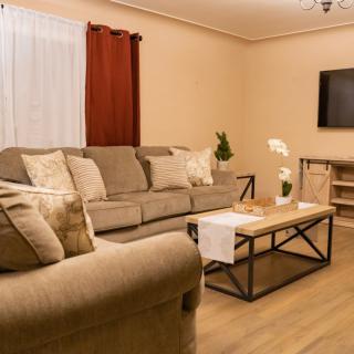 A cozy living room with a comfortable sofa, coffee table, wall-mounted TV, and stylish decor.