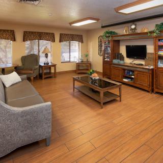 A cozy living room with a modern sofa, wooden coffee table, and entertainment center featuring a television.