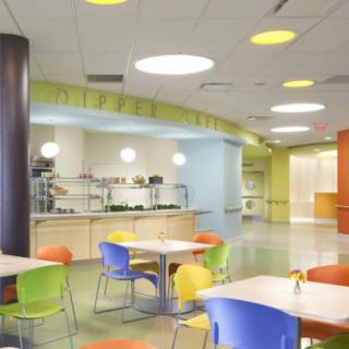 A modern cafeteria with colorful chairs and bright lighting.