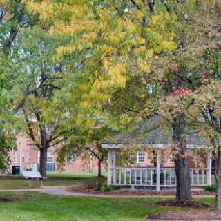 A peaceful park scene with a gazebo surrounded by trees in autumn.