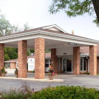 A building entrance with brick columns and a covered driveway.