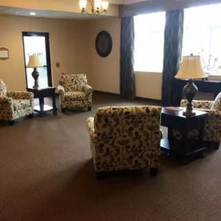A cozy lobby with patterned chairs and lamps.