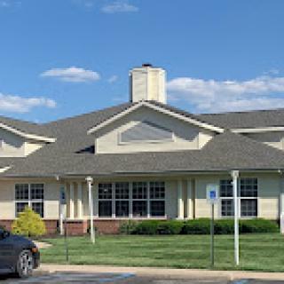A sunny day view of a charming residential building with well-maintained landscaping.