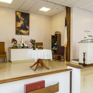 An interior view of a church featuring an altar, pulpit, and religious decorations.
