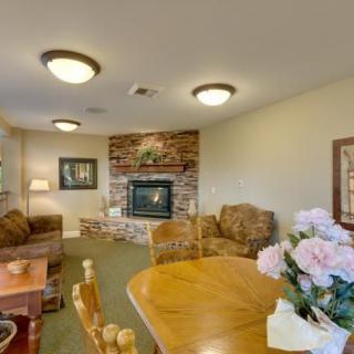 A cozy living room with a fireplace, sofas, and a dining table adorned with flowers.