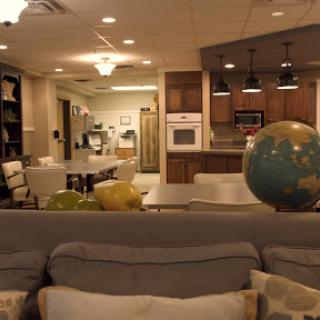 A spacious and inviting living area combined with a kitchen, featuring modern furnishings and a decorative globe.
