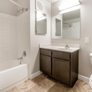 A modern bathroom with a bathtub, sink counter, and mirror.