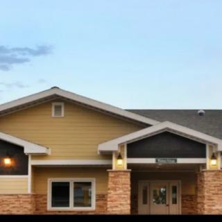A modern residential building with a gabled roof and warm exterior colors.
