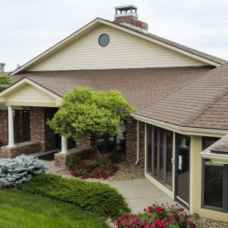 A suburban house with a well-maintained garden and brick facade.