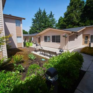 A view of a residential property with a landscaped garden and outdoor seating.