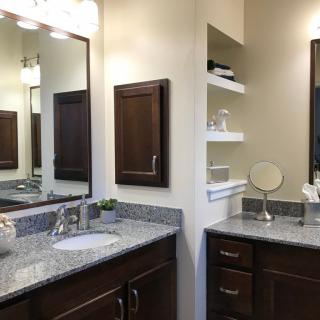 Modern bathroom with granite countertops and ample storage.