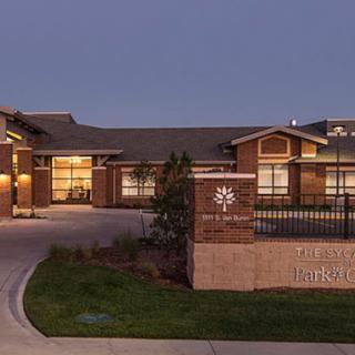 A beautifully designed residential building illuminated at dusk, showcasing modern architecture and inviting surroundings.