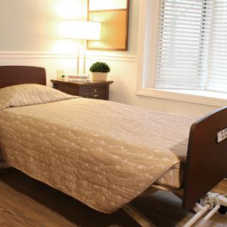 A cozy bedroom featuring a neatly made bed, a bedside lamp, and natural light filtering through the window.