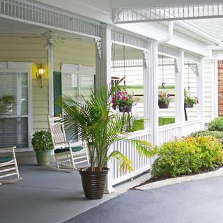 A cozy porch with rocking chairs and potted plants.