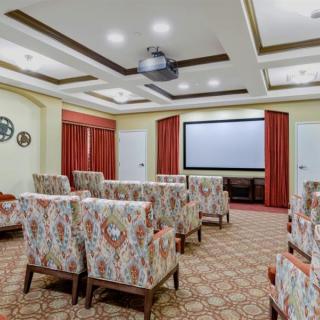 A stylish theater room with decorative chairs and a large projection screen.