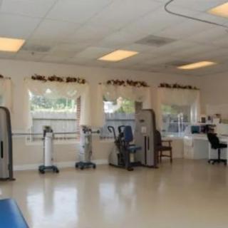 A physical therapy room equipped with exercise machines and spacious flooring.