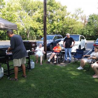 A relaxing summer barbecue gathering with friends enjoying food and conversation.