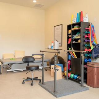 A physical therapy room equipped with parallel bars and rehabilitation equipment.
