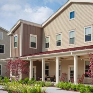 A suburban residential building with a front porch and garden.