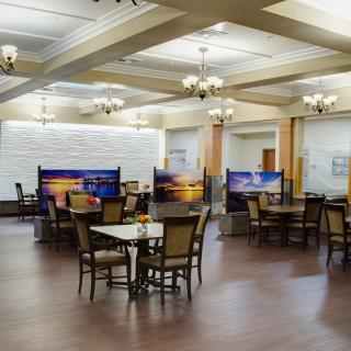 A spacious dining area with elegant chandeliers and partitioned tables.