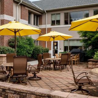 A spacious outdoor patio area with yellow umbrellas and seating arrangements.