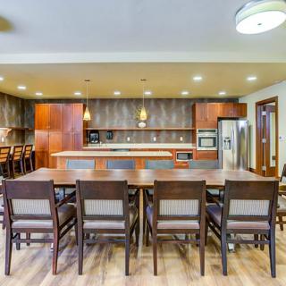 A modern kitchen with an open dining area, featuring wooden furniture and an island countertop.