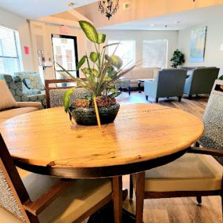 A cozy dining area featuring a wooden table with a houseplant centerpiece and comfortable chairs.