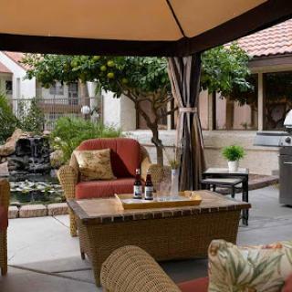 A cozy outdoor patio area featuring comfortable furniture and a grill, perfect for relaxation and social gatherings.