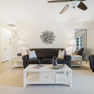 A modern living room featuring a black sofa, white coffee table, and elegant decor.