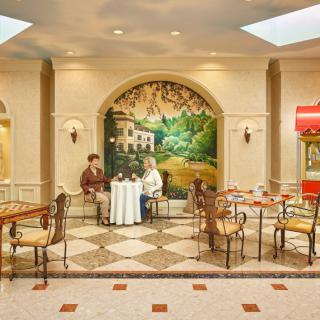 Two people sitting at a table in a cozy cafe with decorative murals on the walls.