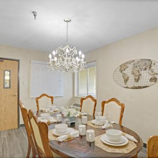 A well-decorated dining room with a chandelier and an elegantly set table.