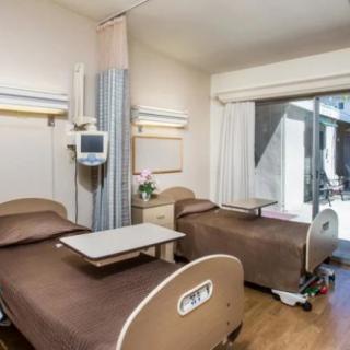 A modern hospital room with two patient beds and medical equipment.