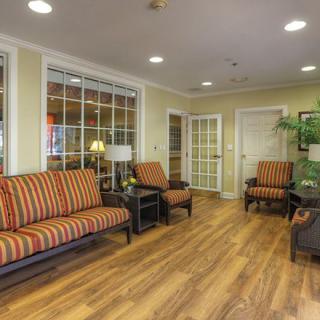 A cozy lobby with striped upholstered seating and wood flooring.