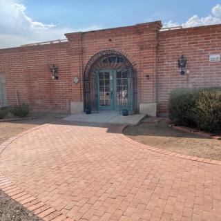 A brick building with an arched entrance and a paved pathway leading to it.