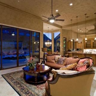 Luxurious open-plan living room with elegant furnishings and a view into the kitchen.
