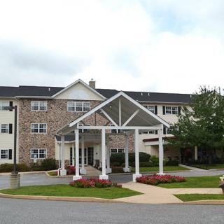 A residential building with a covered entrance and well-maintained landscaping.