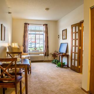 A cozy living room with wooden furniture and a large window.