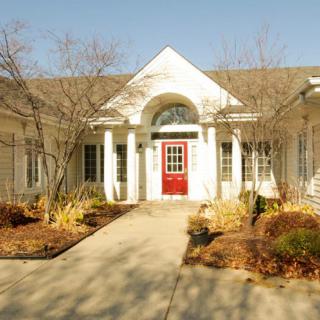 A charming house with a red door and a well-maintained garden pathway.