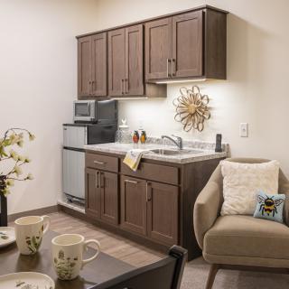 A cozy kitchen and living area featuring wooden cabinets, modern appliances, and comfortable seating.