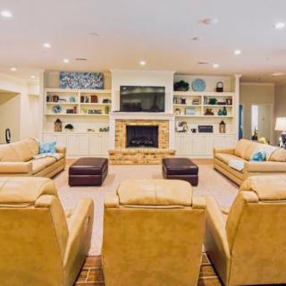 A spacious and cozy living room with comfortable seating, a fireplace, and a television.