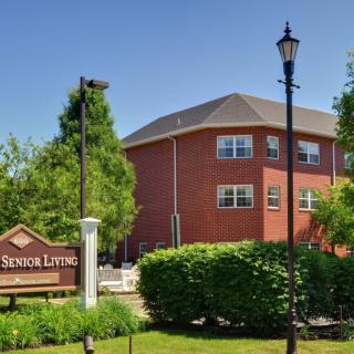 A senior living facility with well-maintained landscaping and a brick exterior.