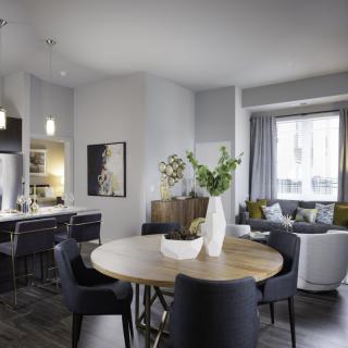 A modern open-concept living and dining area featuring minimalist design with contemporary furniture.